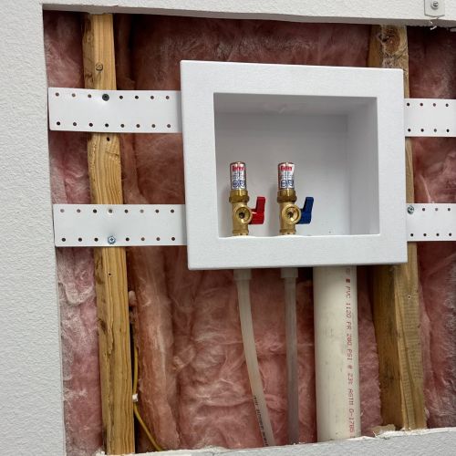 Unfinished wall with washing machine connections